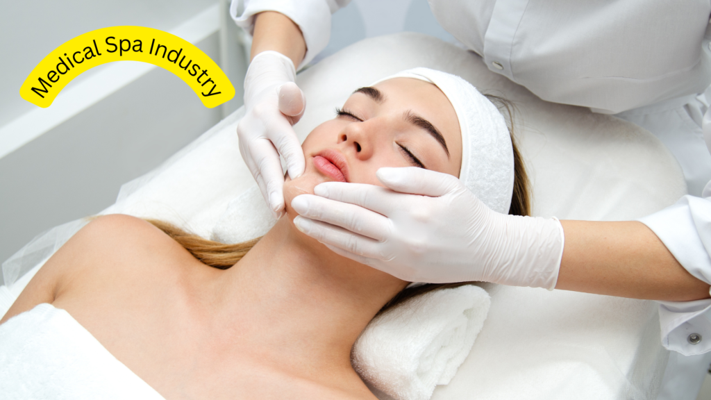A young woman with a white headband lies on a treatment bed, eyes closed, as a person wearing white gloves gently massages her face. The words "Medical Spa Industry" are written in a curved yellow banner in the upper left corner.